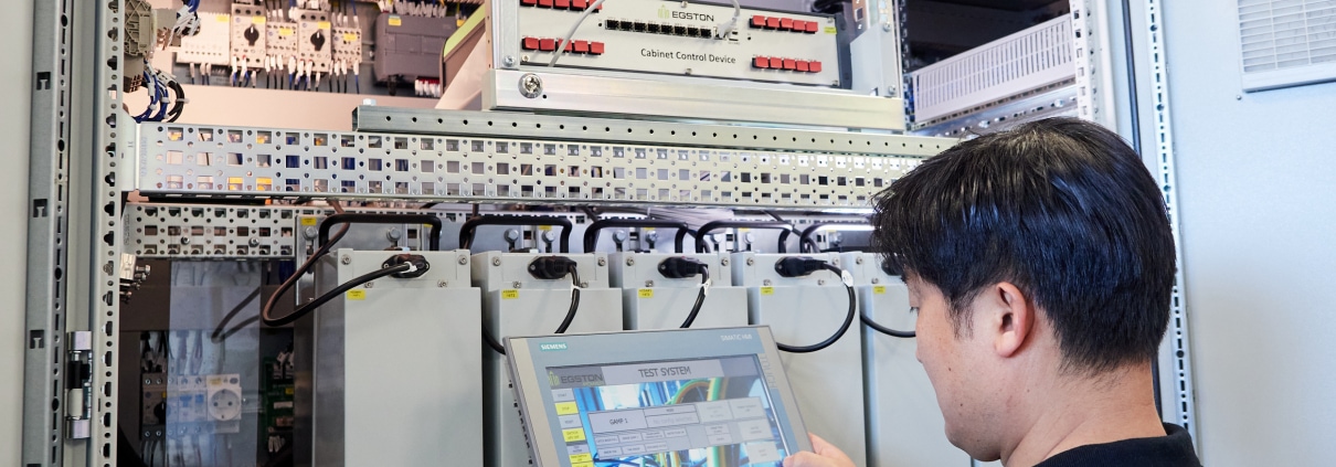 Engineer in front of Compiso with a Test System in his hands